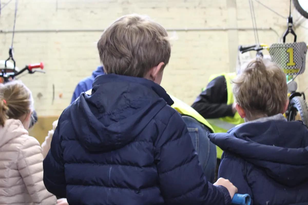 Kinderen wachten op laatste fietscontrole door vrijwilligers Fietsbieb Tervuren